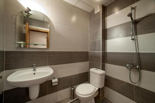 a bathroom with a sink and a toilet and a mirror at Guest House Dzhangal in Bansko