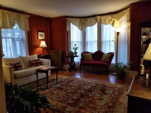 a living room with a couch and chairs and windows at Blackberry Inn in Camden