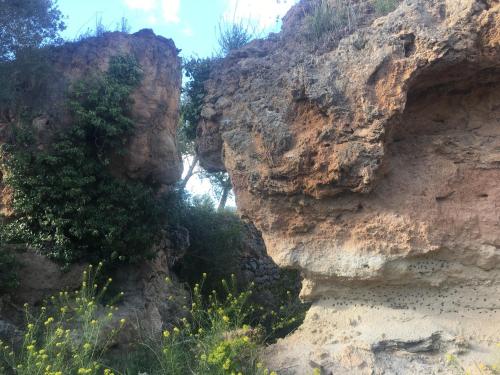 
a large rock wall with a mountain range behind it at Posada Manolon in Santa Cruz de Moya

