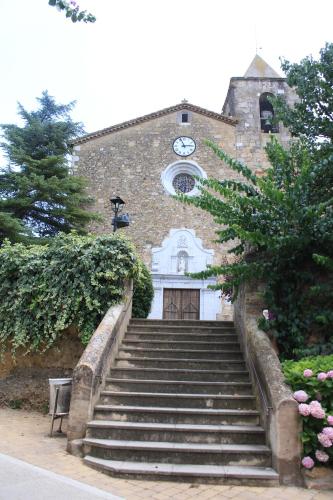 a building with stairs leading up to a building with a clock at Can Quilis in Pontós