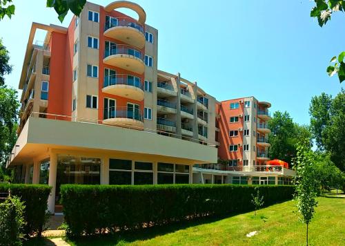 an apartment building with bushes in front of it at Luisa Lux Apartment - Sat Vacanta in Mamaia