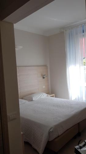 a bedroom with a white bed with a window at Cecio 5 Terre Rooms in Corniglia