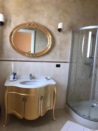 a bathroom with a sink and a mirror and a shower at Villa Belvedere di Rita in Gallipoli