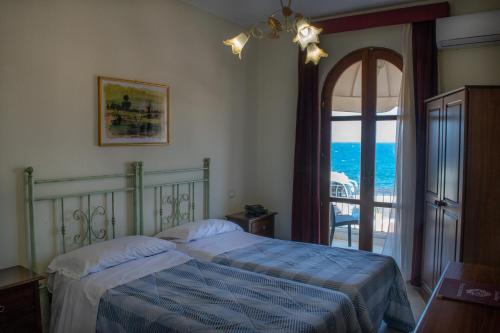 um quarto com uma cama e vista para o oceano em Hotel Porto Azzurro em Giardini Naxos