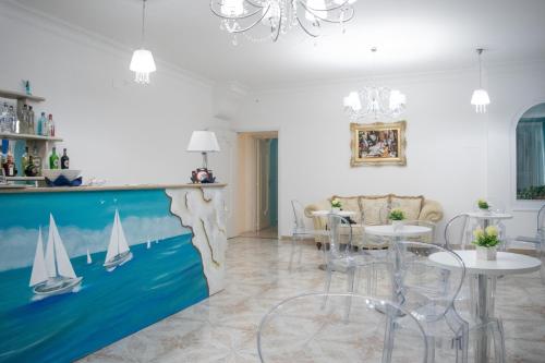 Hotel Porto Azzurro في جيارديني ناكسوس: غرفة معيشة فيها لوحة لقوارب على الحائط