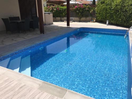 ein Pool mit blauen Fliesen darauf in der Unterkunft Giorgio Vacation House in Pissouri