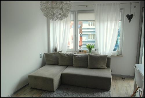 a living room with a couch in front of a window at Apartament Mieszko Kołobrzeg in Kołobrzeg