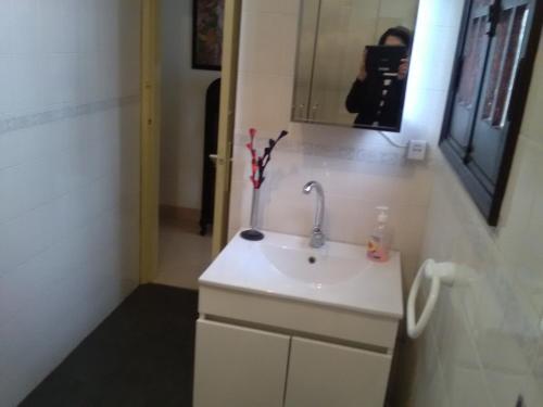 a bathroom with a white sink and a mirror at Comfort Beach house in Nazaré