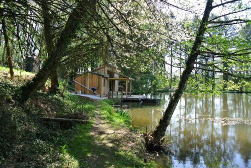 une cabine au milieu d'un lac avec des arbres dans l'établissement GoGreen Cabin, à Saint-Priest-les-Fougères