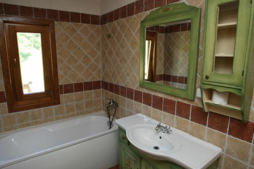 a bathroom with a sink and a tub and a mirror at Gasthaus Maria in Borlova