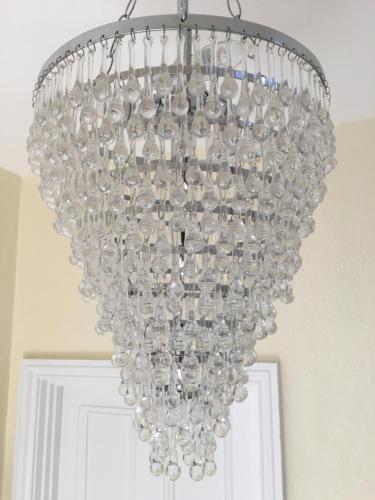 a large glass chandelier hanging from a ceiling at The Queen Hotel in Olney