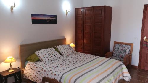 サンミゲル・デ・アボナにあるEmblema Suites 3の小さなベッドルーム(ベッド1台、椅子付)