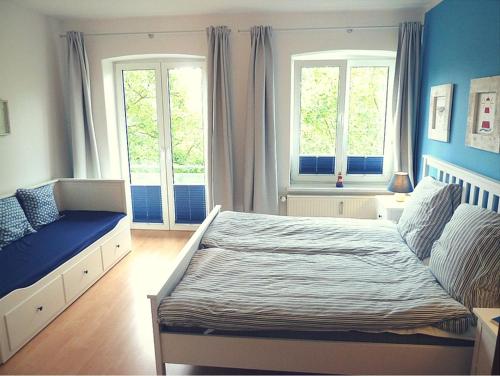 ein Schlafzimmer mit einem großen Bett und zwei Fenstern in der Unterkunft Ferienwohnung Strandläufer in Kühlungsborn