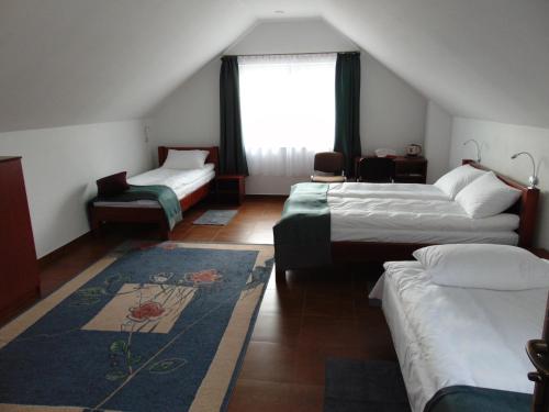 ムロンゴヴォにあるGreen House Marcinkowoのベッド2台と窓が備わるホテルルームです。
