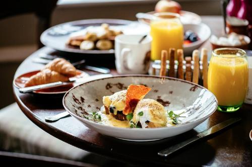 a table with a bowl of food and orange juice at Banchory Lodge Hotel in Banchory