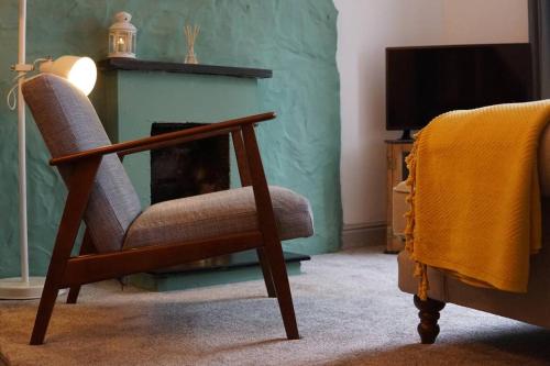 a chair in a living room with a fireplace at Y Gorsaf in Llanfairpwllgwyngyll