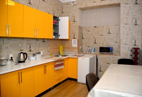 リヴィウにあるGreen Street Hostelのキッチン(黄色のキャビネット、白い冷蔵庫付)