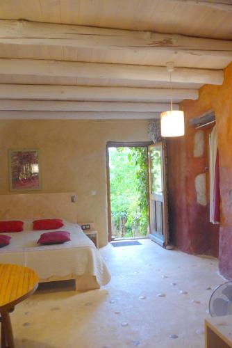 une chambre avec un lit et une grande fenêtre dans l'établissement La Colline Bleue, à Banne