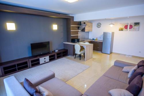a living room with two couches and a kitchen at C&Y Zev Apartments in Mamaia