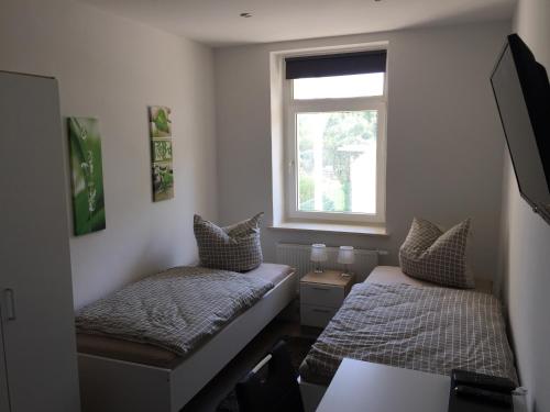 1 dormitorio con 2 camas y ventana en Leipzig-in en Leipzig