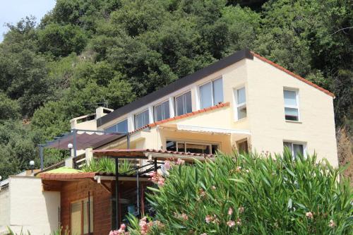 ein Haus auf einem Hügel mit Bäumen im Hintergrund in der Unterkunft Mas Solar D'en Malcion in Amélie-les-Bains-Palalda
