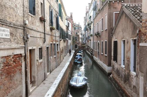 a canal with boats in the water between two buildings at B&B Cà Del Modena in Venice
