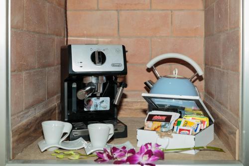 a kitchen counter with a coffee maker and cups at Torres Suite in Polignano a Mare