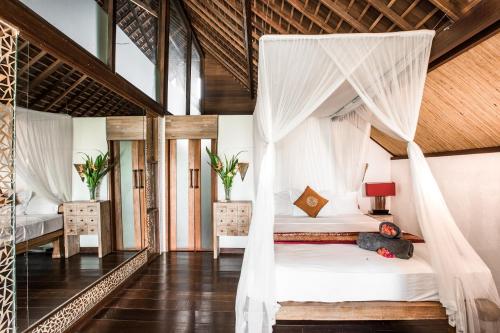 een slaapkamer met twee bedden met klamboes bij Villa Puri Burung in Canggu