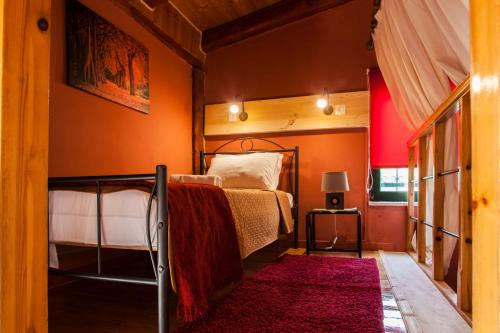 a bedroom with a bed and a red wall at Estate Kares in Tílisos
