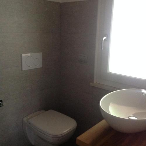 ペルジーネ・ヴァルスガーナにあるRooms dei Minatoriの白いトイレと洗面台のあるバスルーム