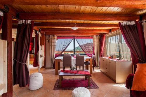 a dining room with a table and chairs and windows at Estate Kares in Tílisos