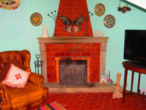 a living room with a red brick fireplace at Casa São João in São João da Serra