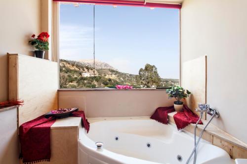 a bath tub in a bathroom with a large window at Estate Kares in Tílisos