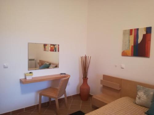 a bedroom with a desk and a chair and a mirror at Praia Del Rei Beach 3 Pools in Amoreira