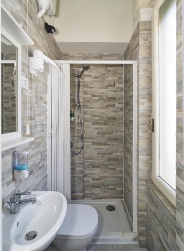 a bathroom with a white sink and a shower at Aliante Turist House in Pisa