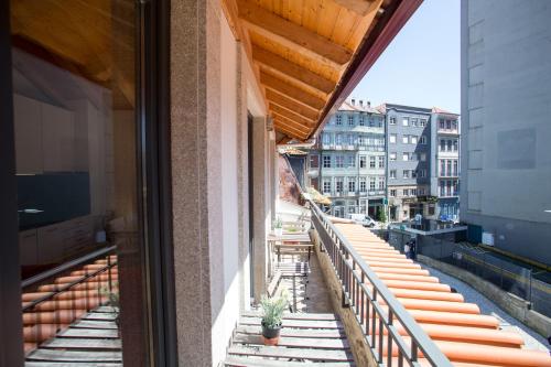 Un balcón con mesas y sillas en un edificio en LivingPorto Apartments by Porto City Hosts, en Oporto