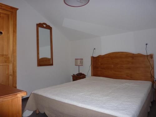 ヴァールにあるRésidence Odalys Pra Sainte Marieのベッドルーム1室(ベッド1台、壁掛け鏡付)