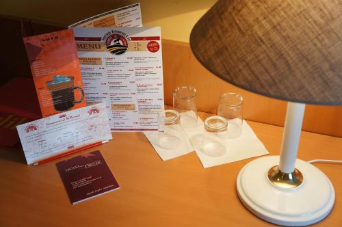 a lamp sitting on a table with certificates and glasses at Hotel Orlik in Płońsk