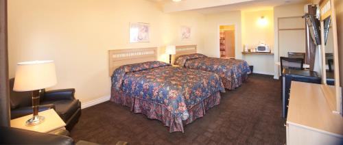 a hotel room with two beds and a lamp at Black Sea Motel in Penticton