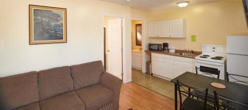 a living room with a couch and a kitchen at Black Sea Motel in Penticton