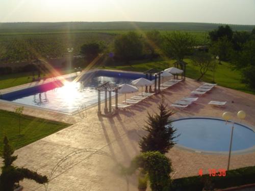 uma vista sobre uma piscina com guarda-sóis brancos em Hotel Acosta Vetonia em Almendralejo