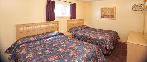 a hotel room with two beds and a window at Black Sea Motel in Penticton