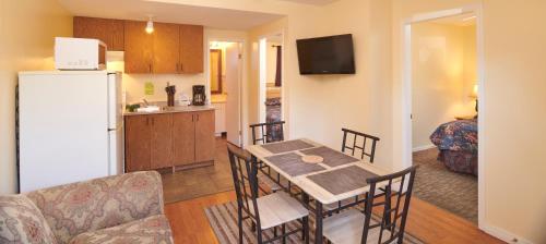 a kitchen and dining room with a table and a refrigerator at Black Sea Motel in Penticton