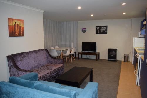 a living room with a couch and a table at Silver Fern Lodge in Taupo