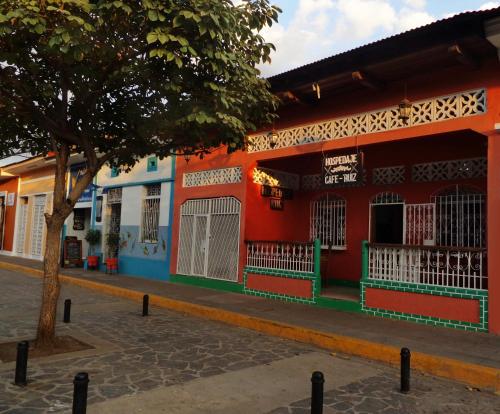 un edificio colorato con un albero di fronte di Hospedaje y Cafe Ruiz a Granada