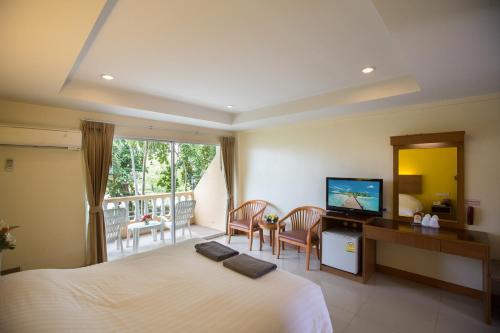 Cette chambre comprend un grand lit et une télévision. dans l'établissement Twin Palms Resort Pattaya, SHA Extra Plus Certified, à Pattaya