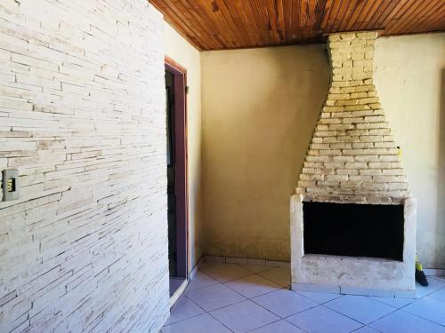 a fireplace in a room with a brick wall at Sitio Vale das Montanhas in São Thomé das Letras