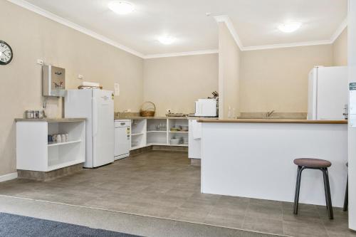 a large kitchen with white appliances and a counter at No 1 Motels in Cambridge