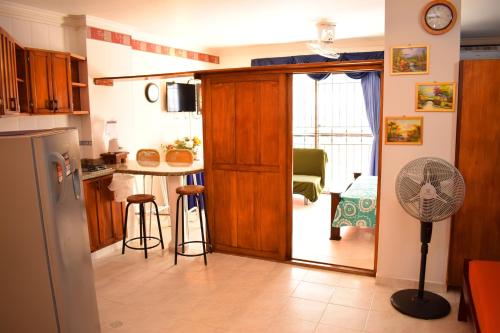 a kitchen with a refrigerator and a table with a fan at APARTAMENTO EDIFICIO LOS LAURELES in Santa Marta