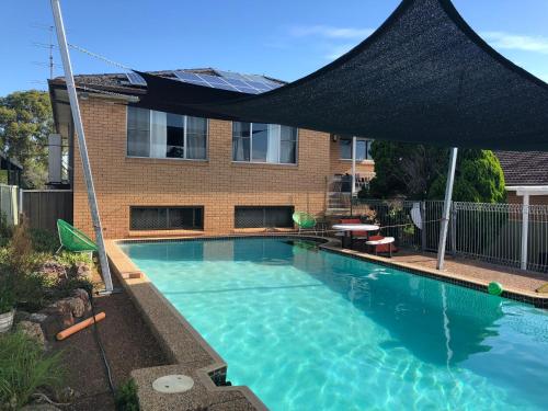 a swimming pool with a black umbrella over it at Coal d' Vine VIEW - Cessnock NSW in Cessnock
